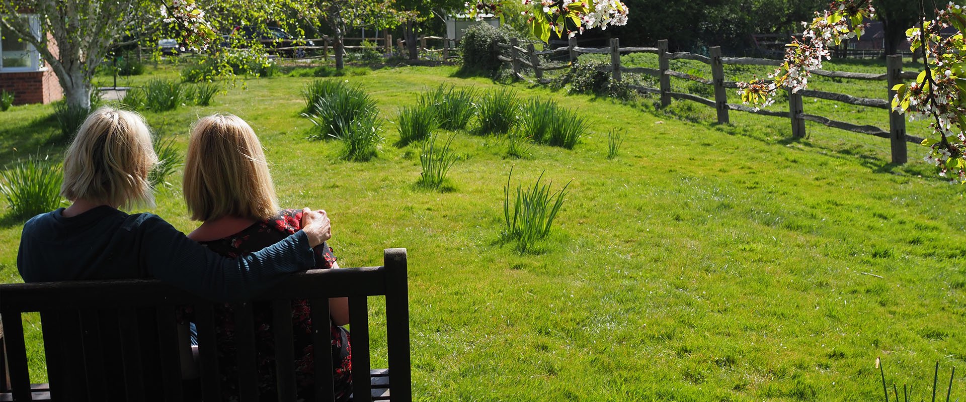 Two woman sat on bench looking into distance